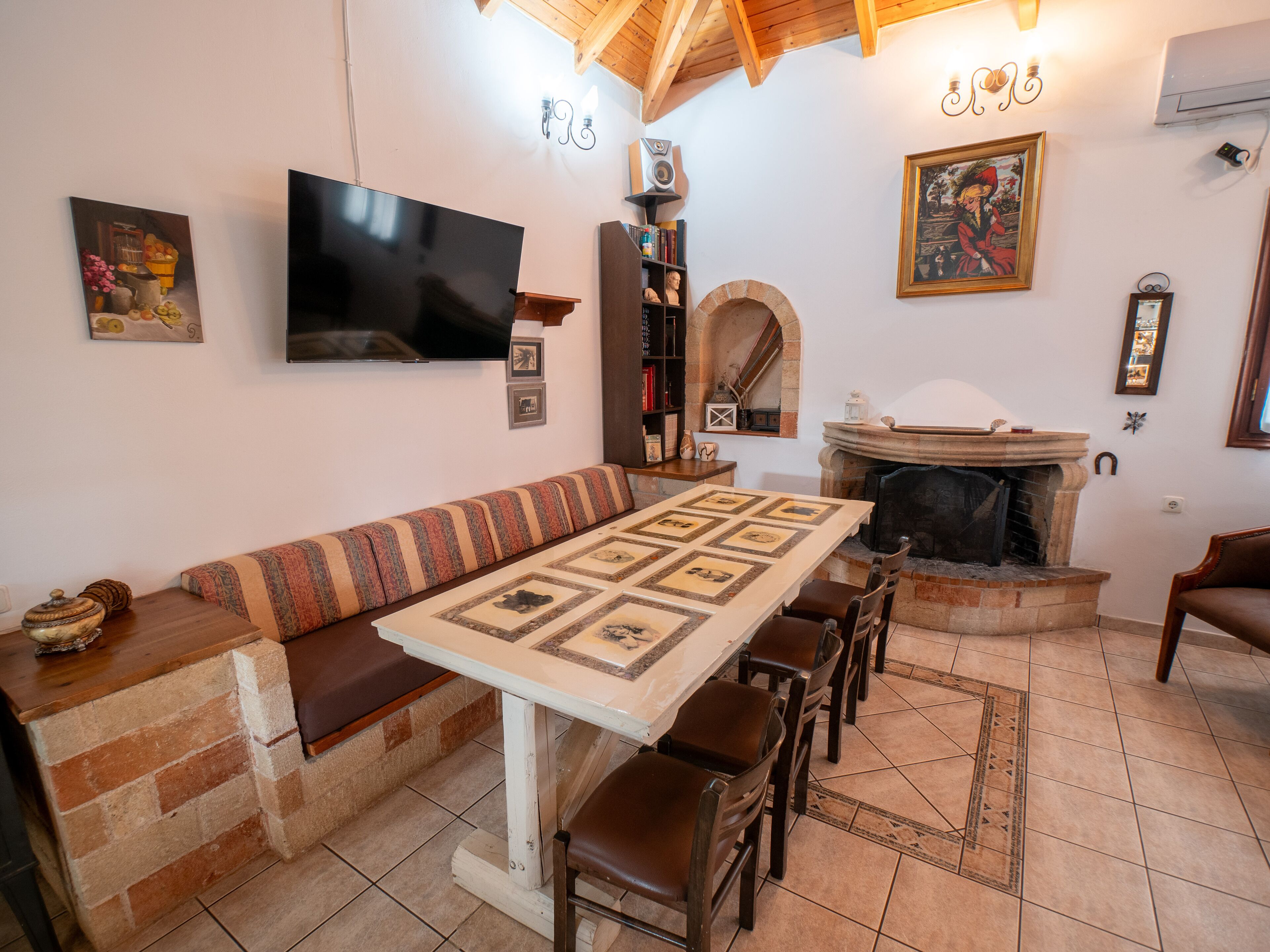 Una sala de estar acogedora con chimenea, televisor y comedor con mesa y sillas.