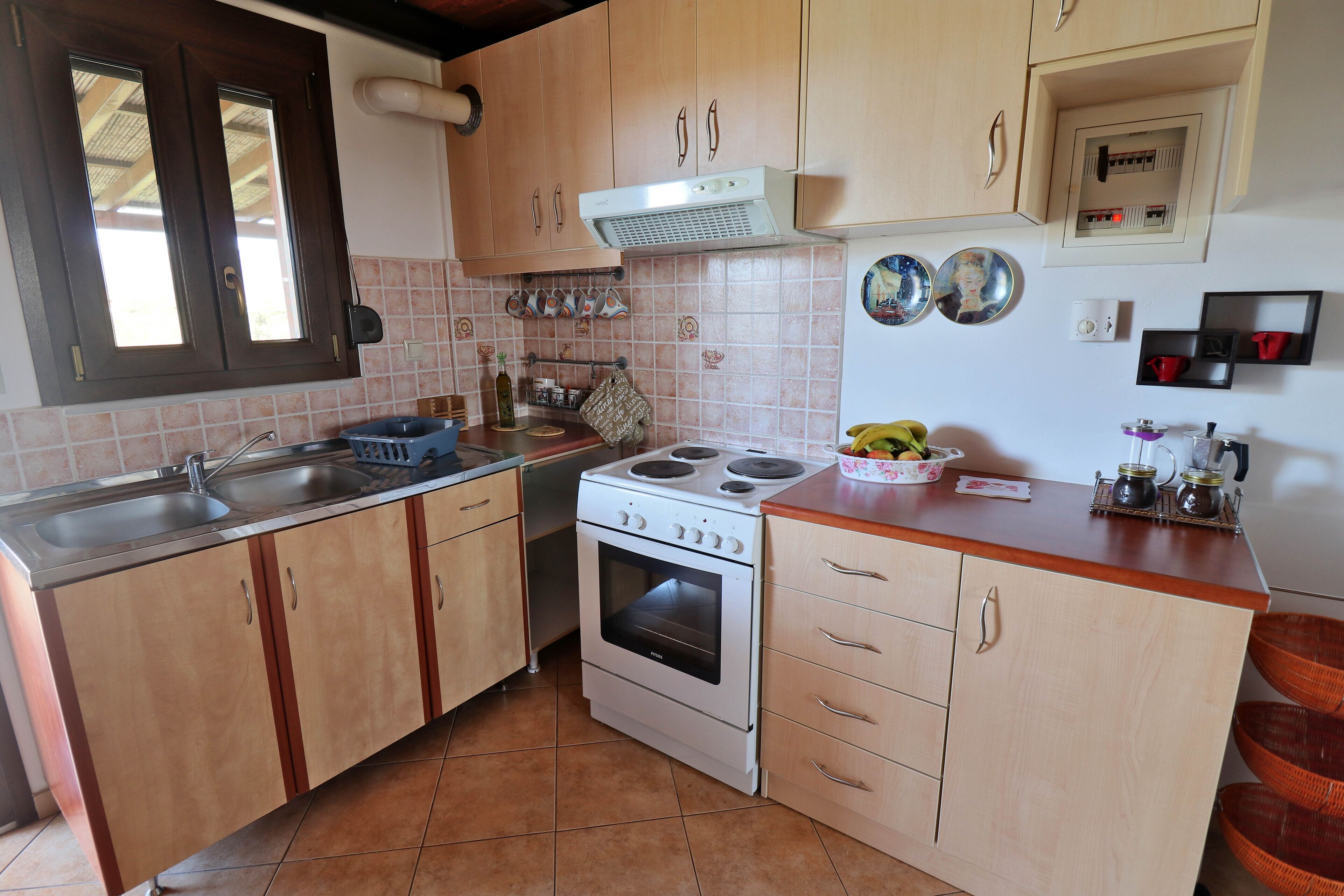 A kitchen with wooden cabinets, a stove, a sink, and a window.