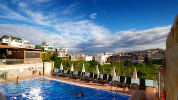 Una piscina al aire libre, camas de piscina gratis, sombrillas