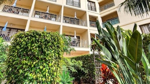 A multi-story hotel with balconies, a courtyard with various plants, and a clear blue sky. - Hapimag Resort Tenerife (Puerto de la Cruz)