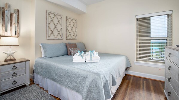 A bedroom with a bed, nightstands, a dresser, and a window with blinds. - 11th Floor 4BR 4BA @ Ocean Ritz (2 SETS OF BEACH CHAIRS INCLUDED) (Panama City Beach)