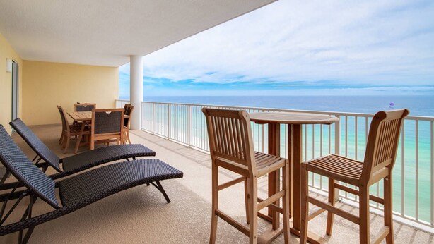 Ein Balkon mit Tisch und Stühlen, der einen freien Blick auf das Meer bietet.