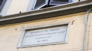 Une plaque sur un bâtiment, avec un texte en italien.