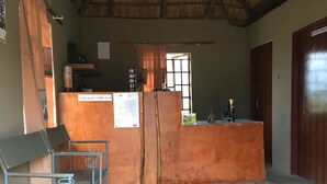 A room with a wooden desk, a chair, a refrigerator, a window, and a door labeled "STAFF ONLY". - Paje River Camp (Paje)