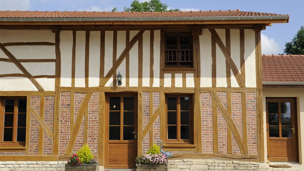 A traditional half-timbered building with a tiled roof, wooden beams, and a small garden area with flowers. - Large comfortable cottage 10 people (Rosnay-l'Hôpital)