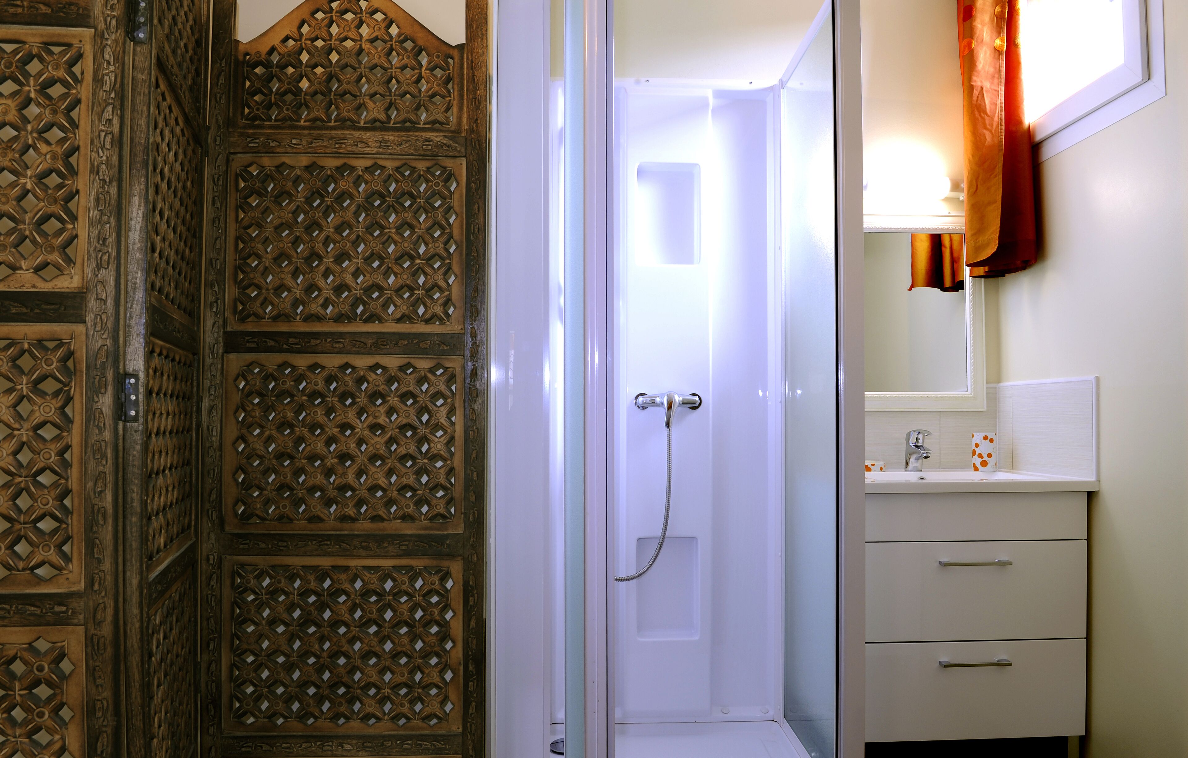 Un baño con ducha, lavabo y espejo.