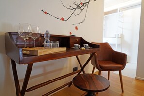 A wooden table with two wine glasses, a water bottle, and a tray with glasses and cups. - Neropece Suites (Ragusa)