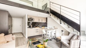 Un espace de vie moderne comprenant un escalier, une cuisine et un coin salon.