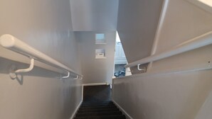 A staircase with white handrails and dark carpeted steps leading to a landing. - Poynters House - Huku Kwetu Luton (Luton)