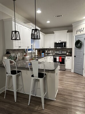Enjoy cooking in this well-equipped kitchen with a central island and bar stools.