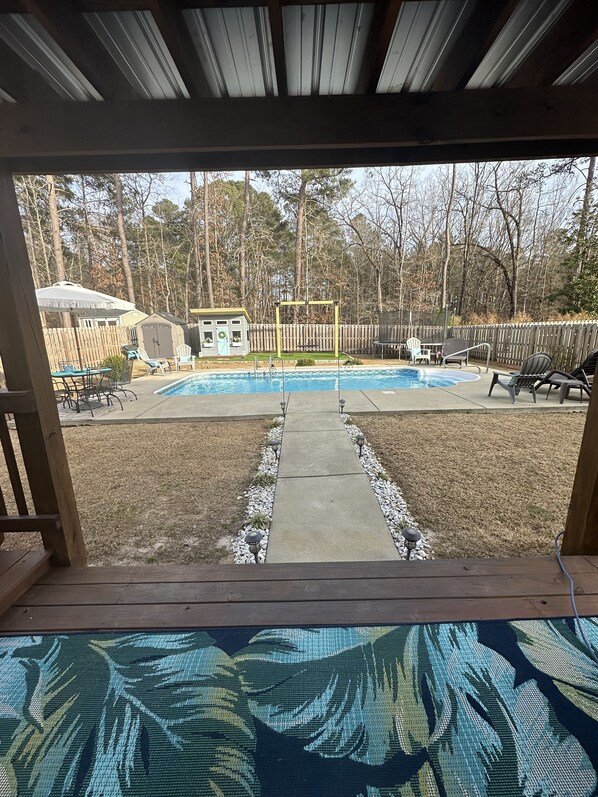 Relax in a serene backyard oasis with a pool, deck, and patio.