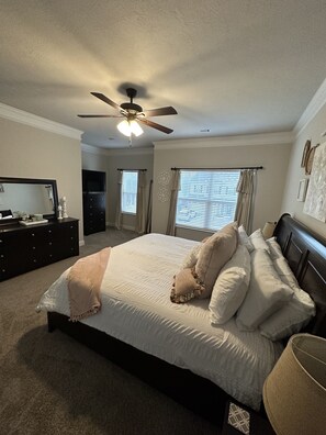 Cozy retreat with a large bed, dresser, and television.