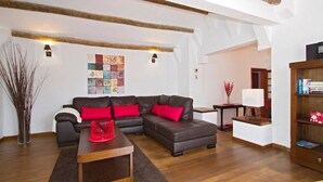 A modern living room with a sectional sofa, a wooden coffee table, and a bookshelf.