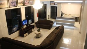 A modern living room with a sofa set, a coffee table, and a flat-screen TV.