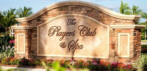 Experience the Players Club & Spa, set amidst lush landscaping with a variety of flowering plants and palm trees.