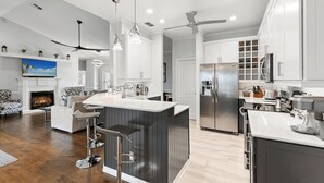 A modern kitchen with a central island, stainless steel appliances, and pendant lighting.