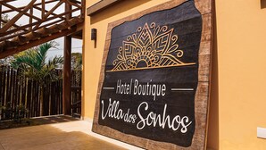 Letrero del Hotel Boutique Villa dos Sonhos con un emblema decorativo.