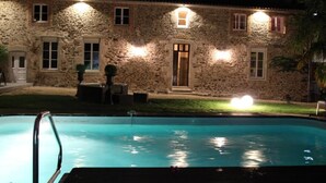 Un edificio de piedra con piscina delantera.