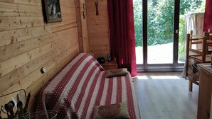 Een gezellig houten kamer met een bed, een tafel en een stoel.