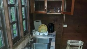 A kitchen with a stove, two sinks, a toaster, a knife, and a dish rack. - Tranquil and Peaceful Parlatuvier (Parlatuvier)