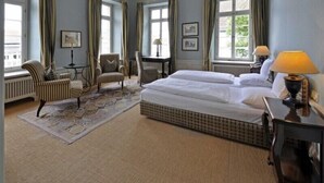A hotel room with a large bed, two armchairs, a small table, and a lamp. - Hotel Herrenhaus von Löw (Bad Nauheim)