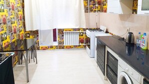 Une cuisine compacte comprenant une table à manger, un lave-linge et un radiateur.