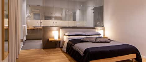 Un dormitorio moderno con una cama de madera, mesitas de noche y un espejo grande.