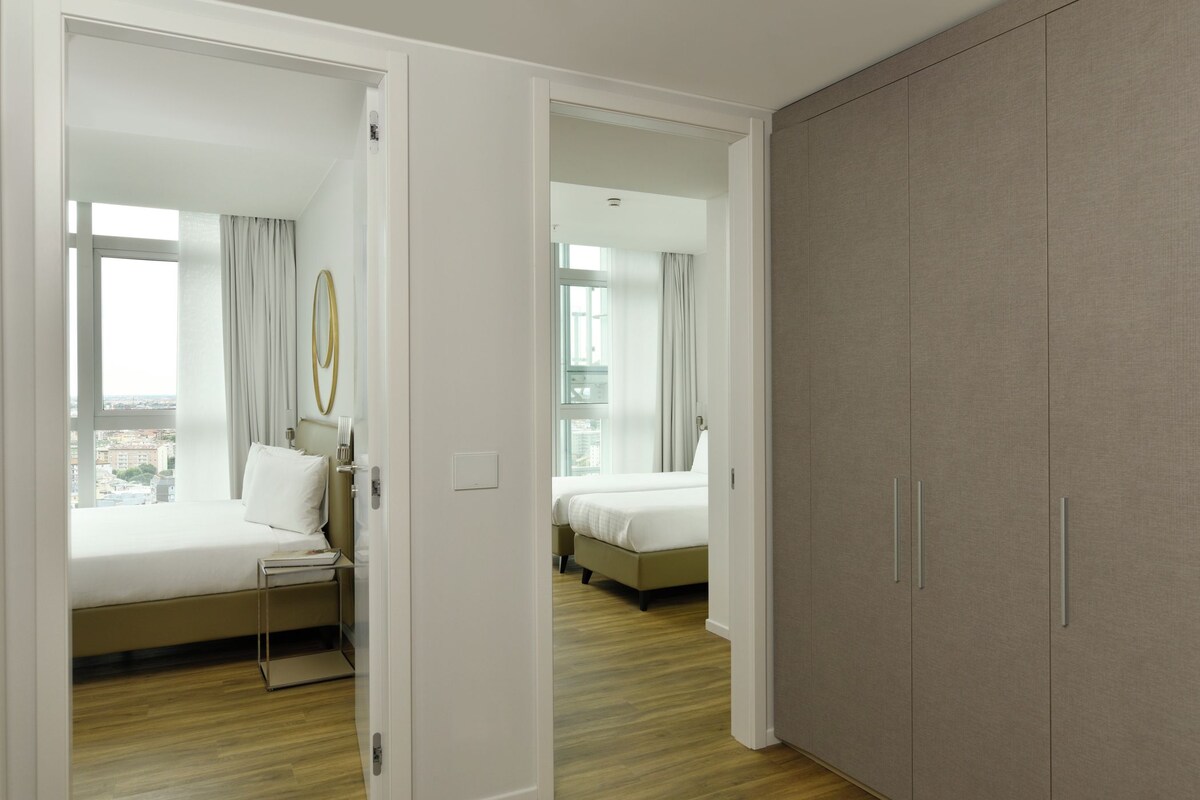 Una habitación de hotel con cama, mesita de noche y armario.