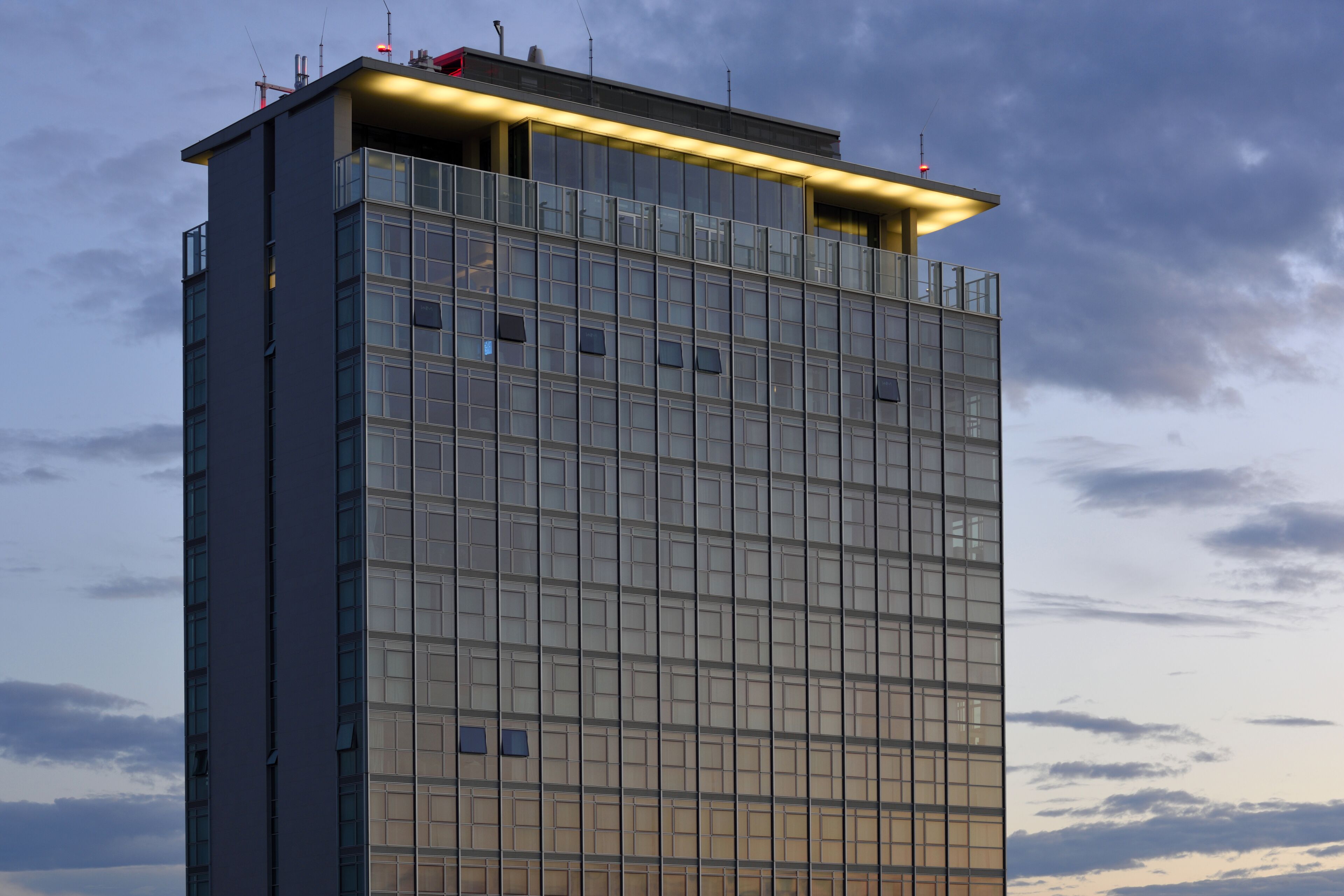 Un immeuble de grande hauteur doté d’une façade moderne en verre et d’un toit plat.