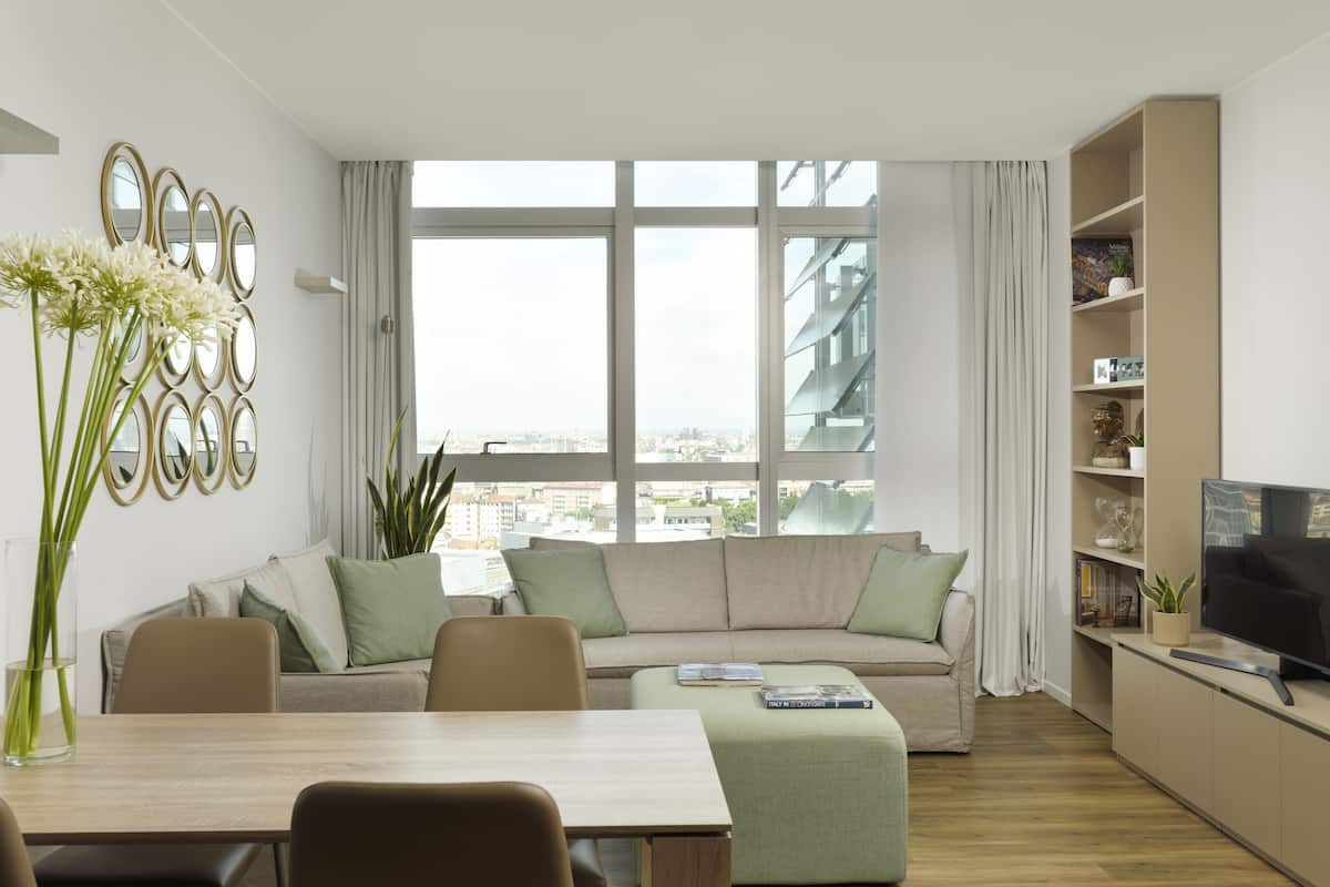 Una sala de estar moderna con un sofá, mesa de comedor y televisor.