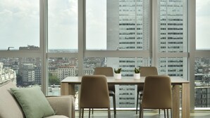 Una habitación moderna con un ventanal grande, una mesa de comedor con sillas y un sofá.