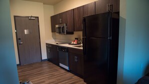 Una cocina moderna con armarios de madera oscura, un refrigerador de acero inoxidable y un microondas.