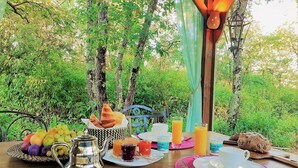 Ein Tisch im Freien mit Frühstücksgebäck, umgeben von üppigem Grün.