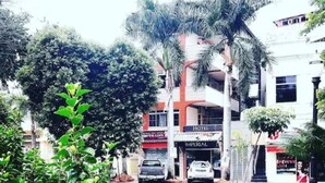 Un hotel con fachada roja y blanca, con un letrero visible del Hotel Imperial y una calle frente a él donde hay coches estacionados.