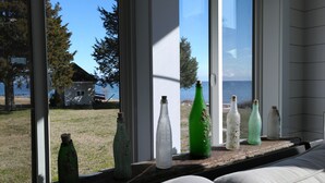 Ein Fenster mit mehreren leeren Flaschen auf einem Sims.