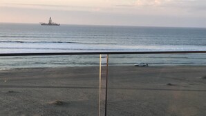 A beach with a view of the ocean and a distant ship. - 32  Bay View Suites  (Langstrand)