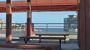 Una pergola in legno con panche che si affaccia su una vista costiera.