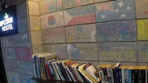 Una parete rivestita di piastrelle colorate e uno scaffale di libri.