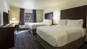 A hotel room with two beds, a desk, a chair, a TV, and a window with curtains. - Cobblestone Inn & Suites - Brookville (Brookville)