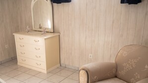 A room with a white dresser, a mirror, a beige sofa, and a tiled floor. - Homerez - Apartment in Breuillet (Breuillet)