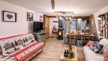 A cozy living room with a sofa, a television, and a fireplace.