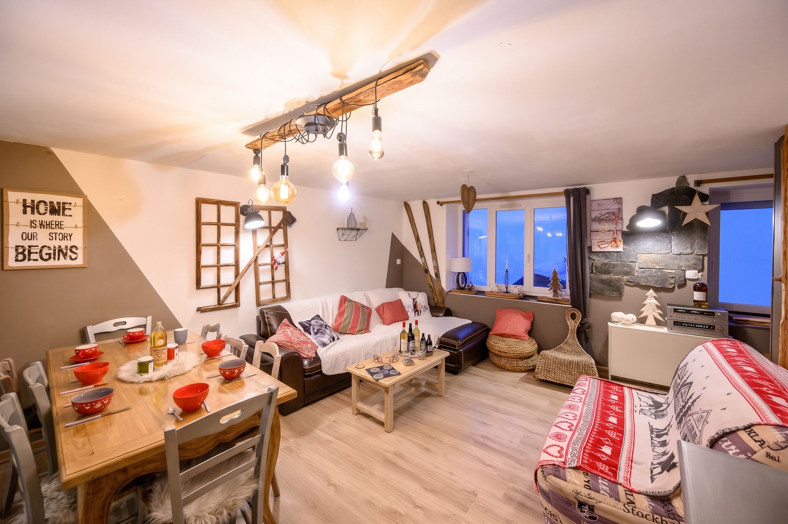 A cozy living room with a wooden dining table, a sofa, and a television.
