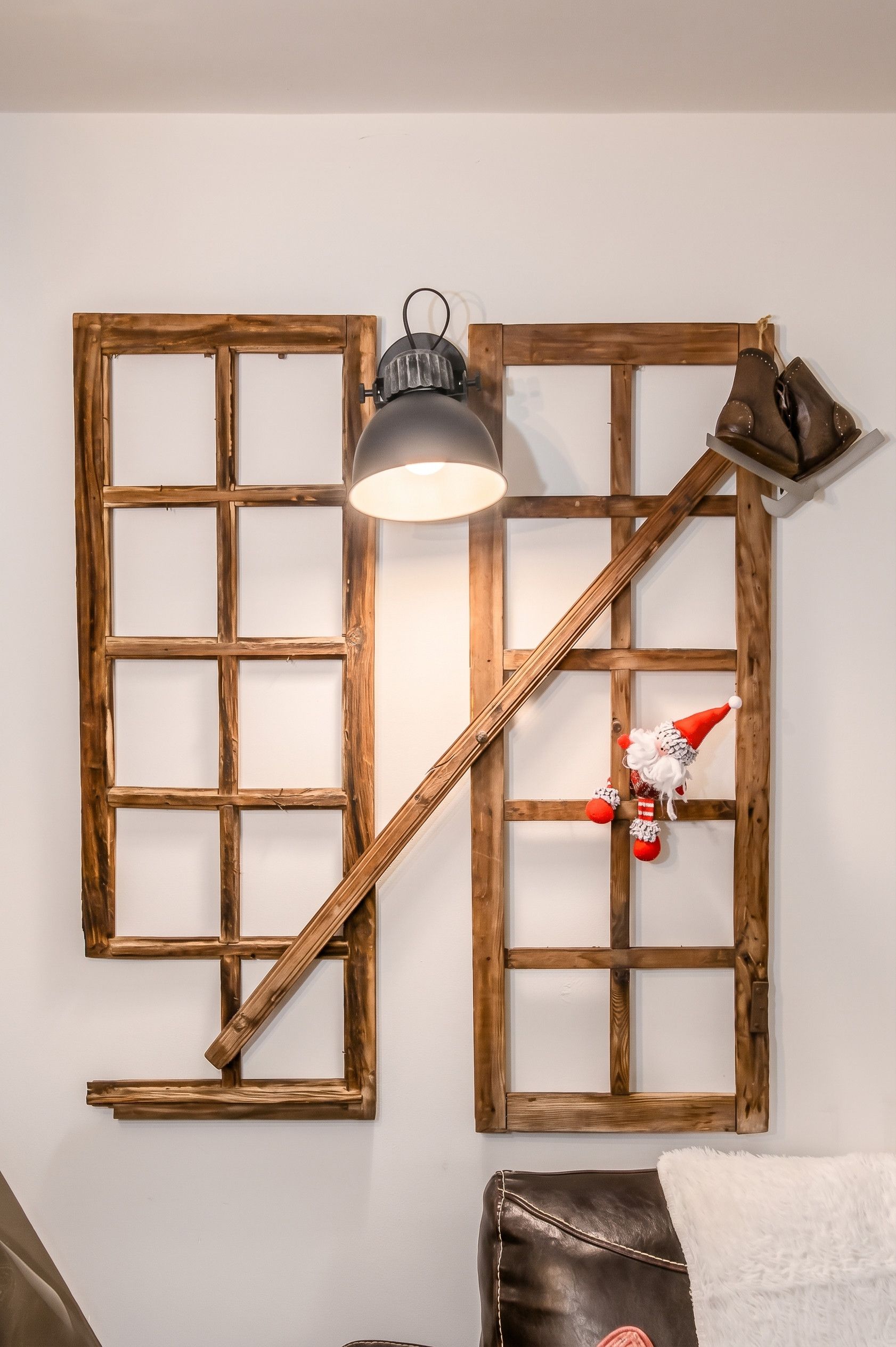 A room with a wooden window frame wall decoration, a hanging lamp, and a plush toy.