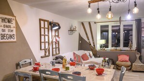 A dining area with a table set for four, surrounded by chairs.