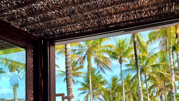 A poolside view with palm trees, lounge chairs, and a clear sky. - Vila Bela Vista Corumbau (Prado)