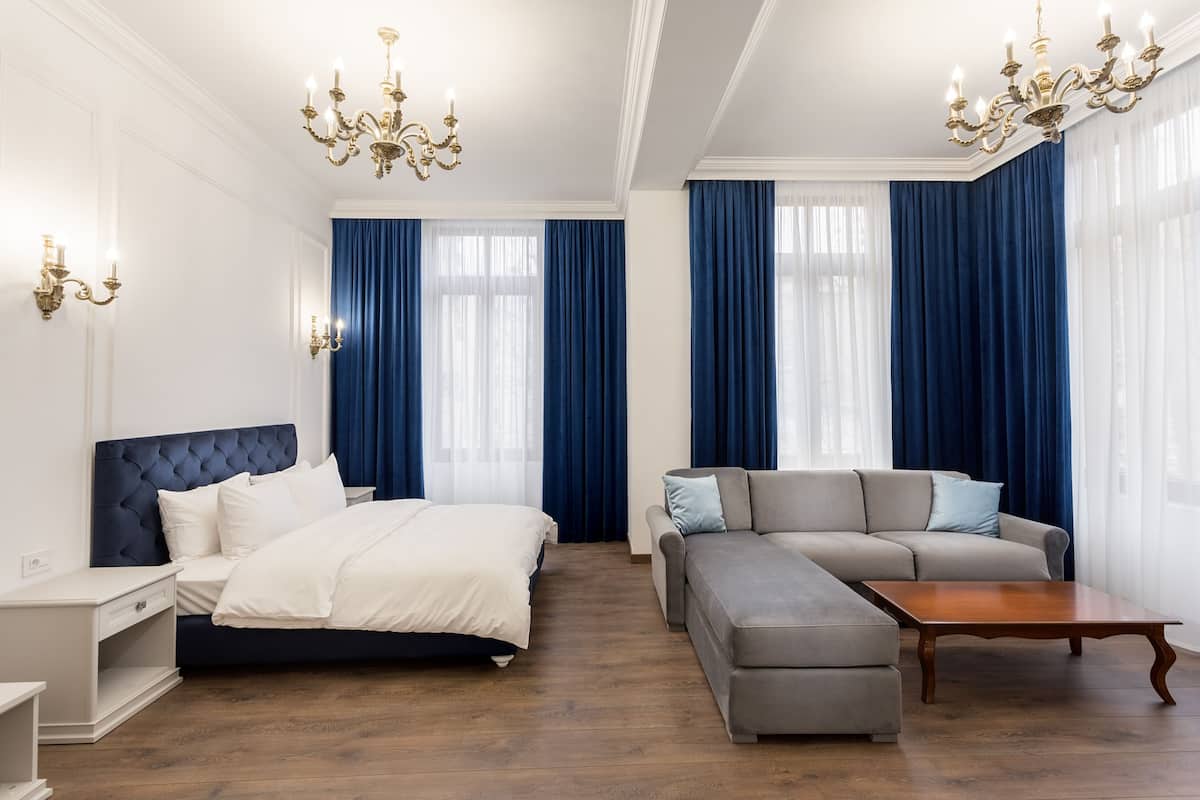 Ein modernes Hotelzimmer mit Bett, Sofa und einem Holztisch.