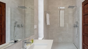 Une salle de bain moderne avec un grand lavabo, deux douches et un miroir.