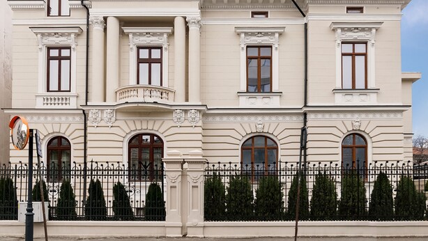Un grand bâtiment de style classique, doté de nombreuses fenêtres et d’un balcon imposant.