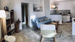 Un salon moderne avec un canapé, une table basse, une lampe et une bibliothèque.