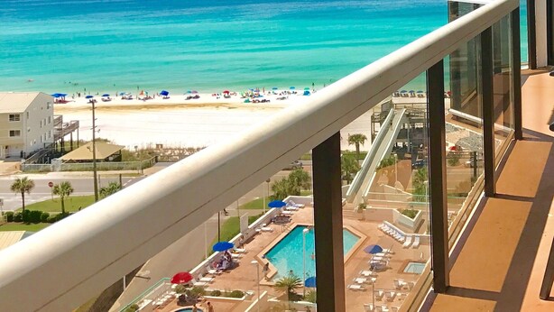 A balcony with a view of a beach and ocean.
